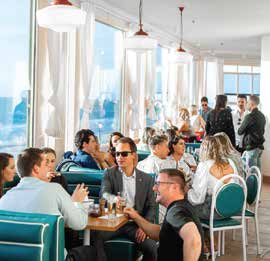 Guests dining beside panoramic ocean-view windows